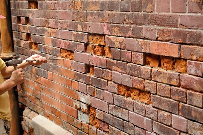 Masonry brick wall being repointed